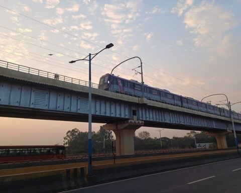Pune Metro train running on the elevated viaduct between Bopodi and Dapodi during sunset.
