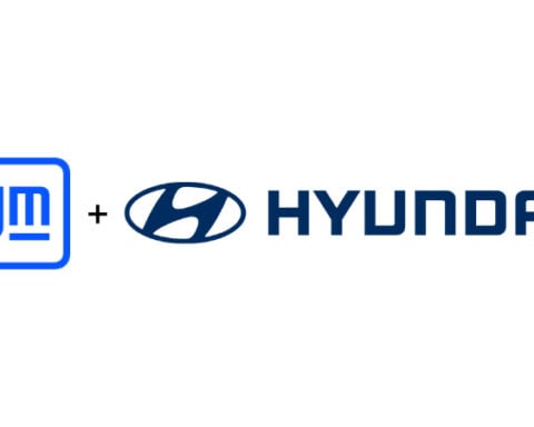 The blue GM logo and the Hyundai logo side by side with a plus sign between them on a white background.