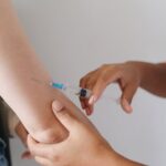 Close-up of a healthcare worker injecting a vaccine into an upper arm