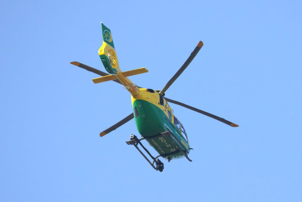 A yellow-and-green Airbus H135 helicopter operated by the Hampshire & Isle of Wight Air Ambulance, parked on the tarmac at Gloucestershire Airport, photographed in May 2017.