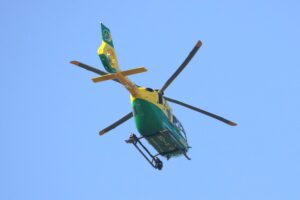 A yellow-and-green Airbus H135 helicopter operated by the Hampshire & Isle of Wight Air Ambulance, parked on the tarmac at Gloucestershire Airport, photographed in May 2017.