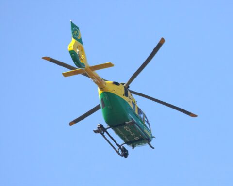 A yellow-and-green Airbus H135 helicopter operated by the Hampshire & Isle of Wight Air Ambulance, parked on the tarmac at Gloucestershire Airport, photographed in May 2017.