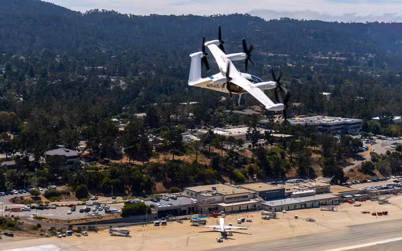 Joby Aviation electric eVTOL air taxi aircraft flying over residential area during historic first piloted flight between two US public airports in California
