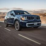 Kia Telluride SUV cruising through a desert highway