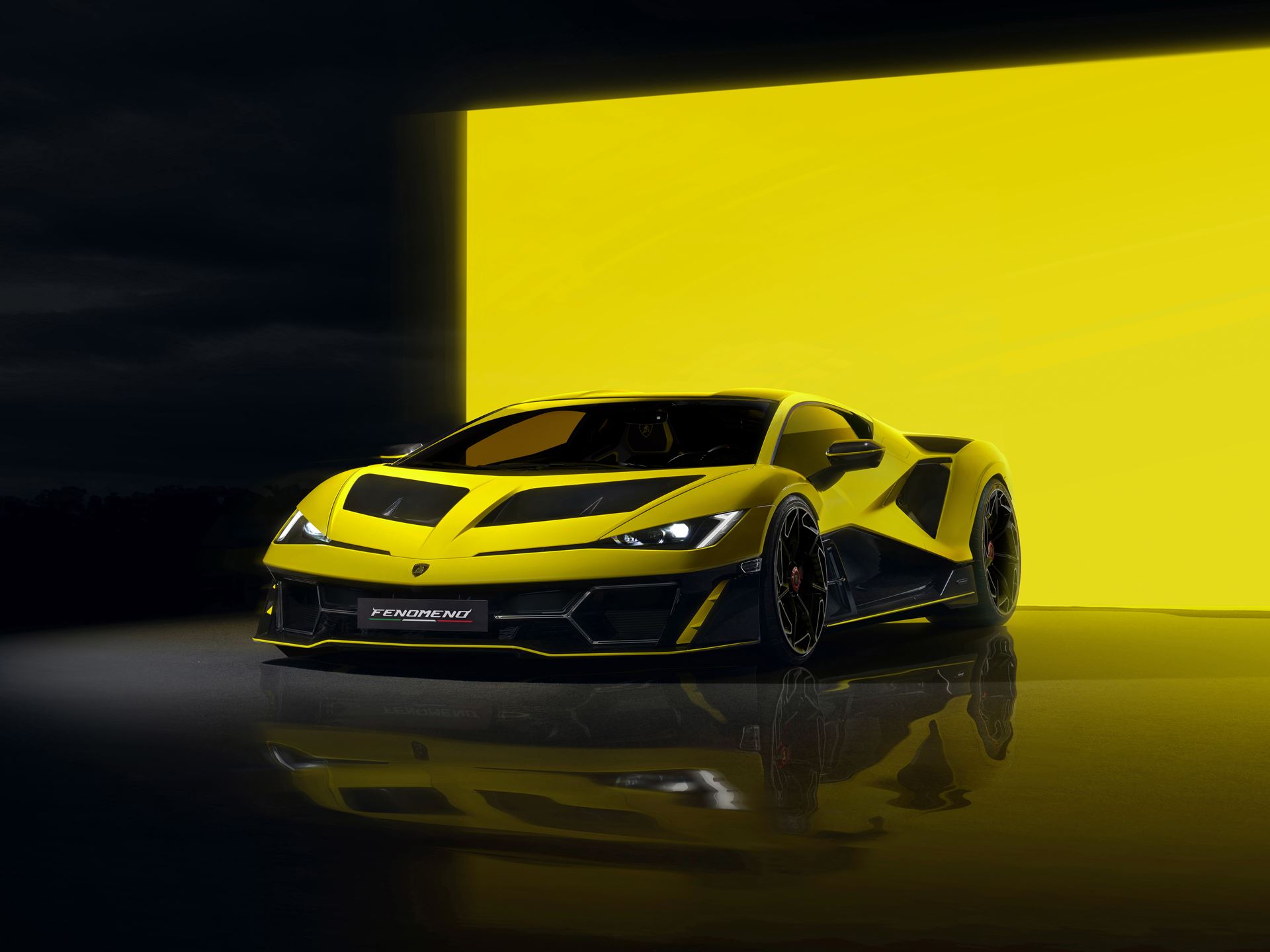 Yellow Lamborghini Fenomeno hypercar with angular design and distinctive black accents displayed against a matching yellow background, highlighting its aggressive aerodynamic styling and low-slung profile.