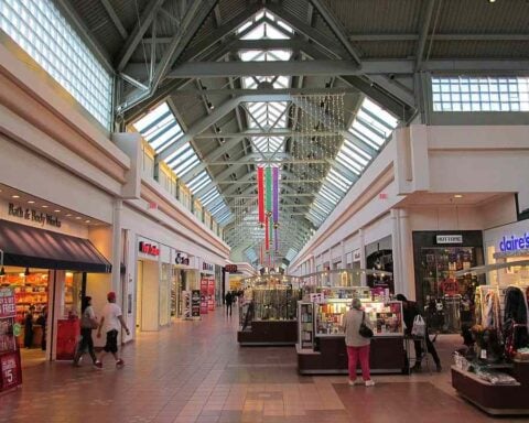 Interior of Greendale Mall in Worcester, Massachusetts, showing retail stores and shoppers walking along a wide indoor corridor.