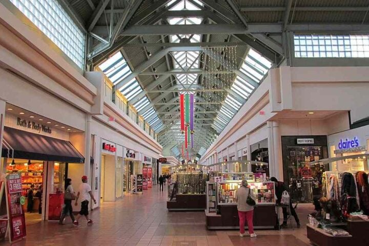 Interior of Greendale Mall in Worcester, Massachusetts, showing retail stores and shoppers walking along a wide indoor corridor.
