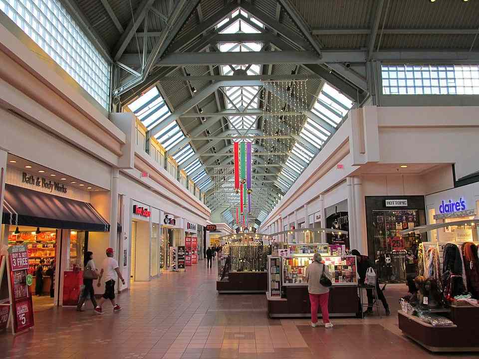 Interior of Greendale Mall in Worcester, Massachusetts, showing retail stores and shoppers walking along a wide indoor corridor.