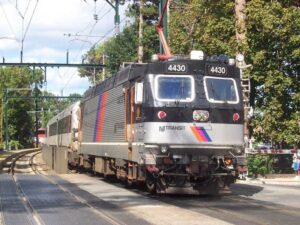 NJ Transit ALP-44M electric locomotive number 4430 traveling through a tree-lined section of track in New Jersey