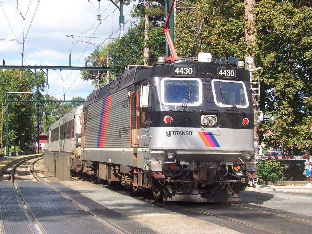 NJ Transit ALP-44M electric locomotive number 4430 traveling through a tree-lined section of track in New Jersey