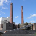 T.B. Simon Power Plant with tall brick smokestack and industrial buildings at Michigan State University campus in East Lansing, Michigan.