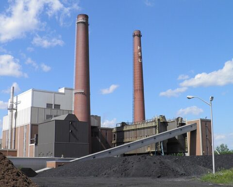 T.B. Simon Power Plant with tall brick smokestack and industrial buildings at Michigan State University campus in East Lansing, Michigan.