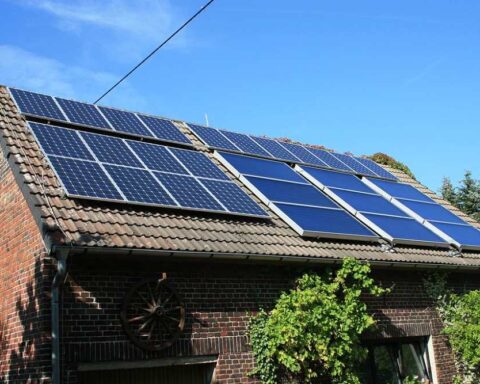 Barn roof in Western Europe with multiple solar panels installed, part of a combined heat and power system generating electricity and heat.