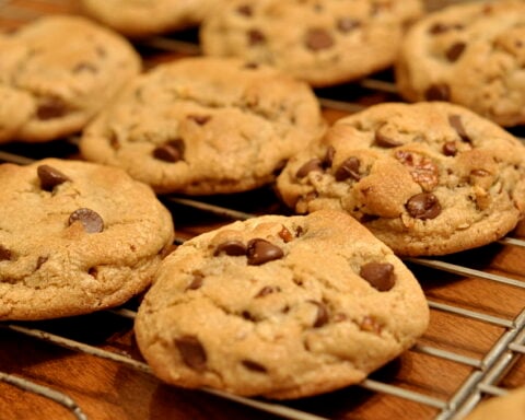 Freshly baked chocolate chip cookies cooling on a wire rack.