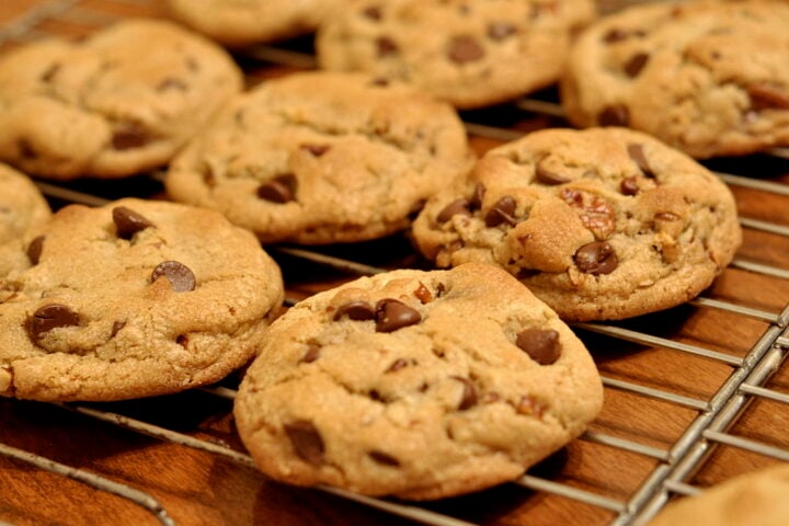 Freshly baked chocolate chip cookies cooling on a wire rack.