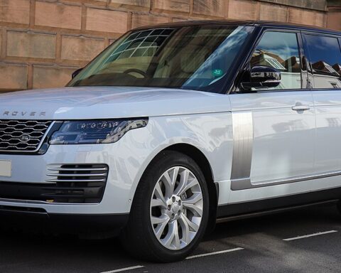 Front-left view of a white Range Rover Autobiography SDV8 parked near a brick wall.
