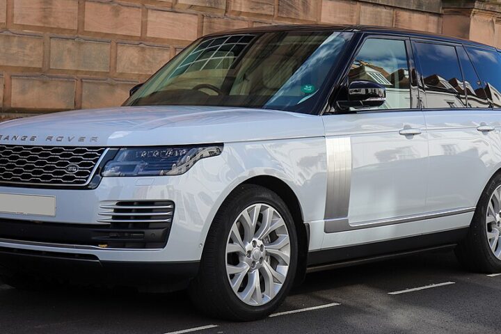 Front-left view of a white Range Rover Autobiography SDV8 parked near a brick wall.