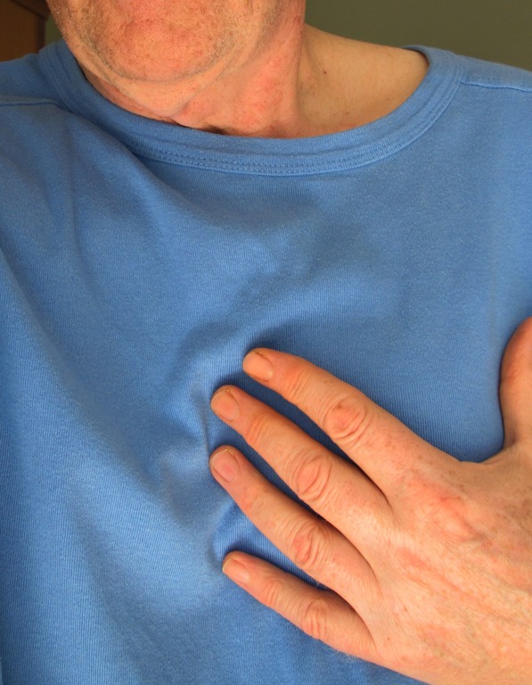 Person wearing a blue shirt with a hand on the chest, suggesting possible chest discomfort