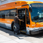 Orange all-electric Roseville Commuter bus with ‘Special Service’ on the display, with a rider boarding.