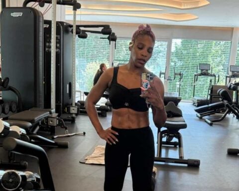 Serena Williams taking a mirror selfie in a gym wearing black workout attire, showing her toned abdomen and physique.