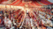 Rows of dozens of Indian brides and grooms in traditional attire seated side by side under a decorated canopy during a large-scale community mass marriage ceremony.