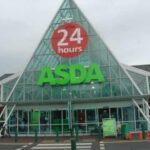 Front entrance of Asda Blackburn supermarket with “24 hours” sign above the main glass façade.