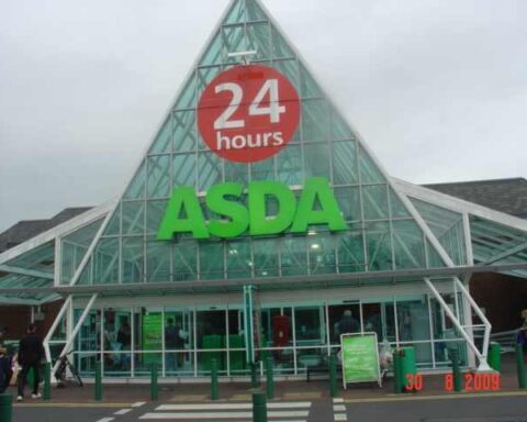 Front entrance of Asda Blackburn supermarket with “24 hours” sign above the main glass façade.