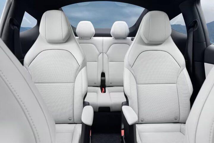Interior view of Tesla Model YL showing white leather seats in a 2-2-2 configuration with individual captain's chairs in the second row and a clear path to the third row, highlighting the vehicle's premium 6-seat layout.