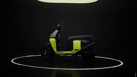 TVS Orbiter electric scooter in matte metallic finish displayed at launch event, positioned in front of large “O” backdrop.