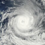 Representative satellite image illustrating a tropical cyclone over open ocean waters, used to accompany hurricane-season coverage.