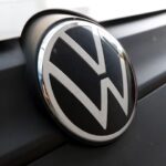 Volkswagen logo and showroom entrance with modern glass facade and illuminated VW emblem