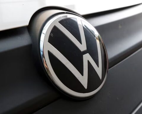 Volkswagen logo and showroom entrance with modern glass facade and illuminated VW emblem