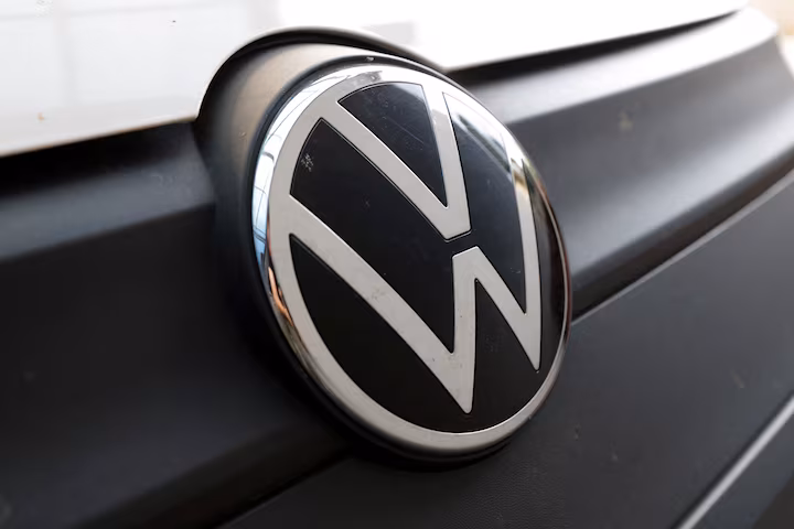 Volkswagen logo and showroom entrance with modern glass facade and illuminated VW emblem