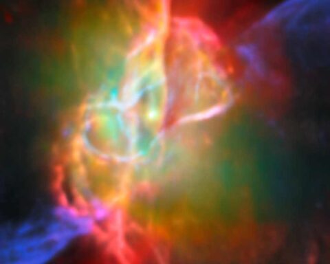 Colorful infrared image of the Butterfly Nebula's center showing a bright central star surrounded by greenish nebulosity and looping structures in cream, orange, and pink colors, captured by Webb telescope and ALMA.