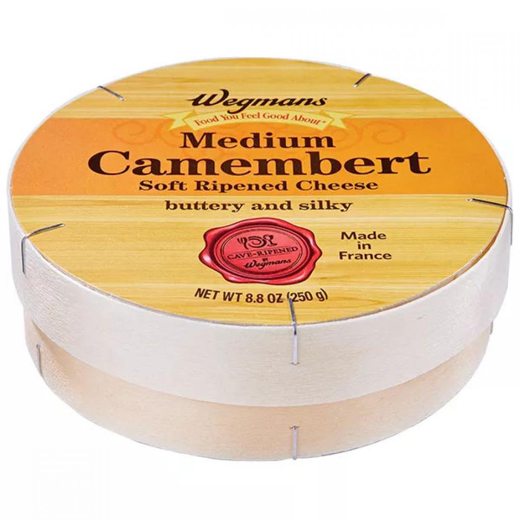 Round wooden box of Wegmans Medium Camembert Soft Ripened Cheese with French origin label and red cave-ripened seal