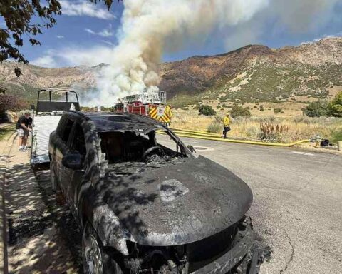 Smoke from the Willard Peak Fire above North Ogden, Utah, with foothills visible and haze affecting nearby neighborhoods.