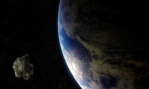 Asteroid approaching Earth against the black background of space, with the blue planet visible in the frame.