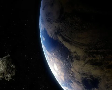 Asteroid approaching Earth against the black background of space, with the blue planet visible in the frame.