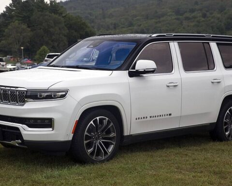 White 2022 Jeep Grand Wagoneer Series III SUV parked on grass at an outdoor showcase.
