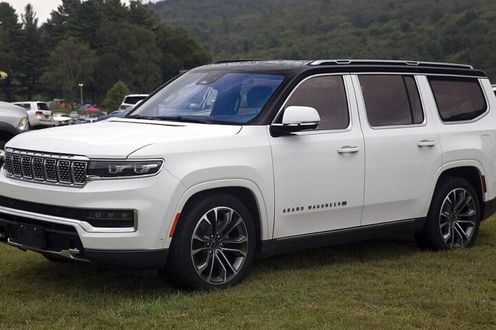 White 2022 Jeep Grand Wagoneer Series III SUV parked on grass at an outdoor showcase.