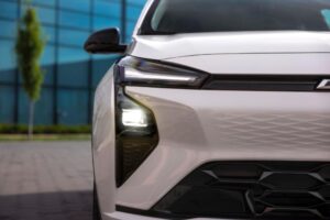 LED headlight with bright daytime running lights on white electric vehicle front end