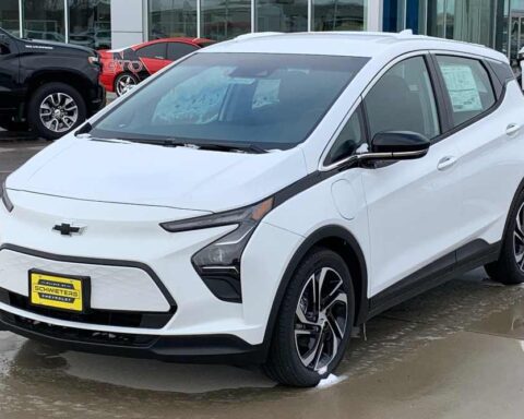 White 2022 Chevrolet Bolt EV compact electric vehicle parked in a dealership lot with other cars visible in the background