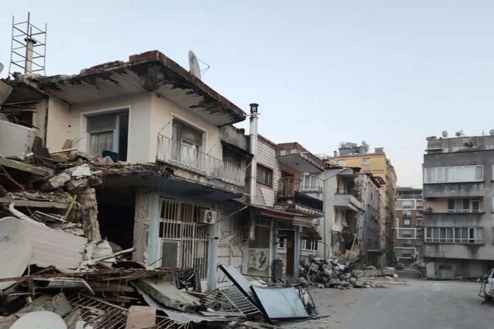 Representative Image. Severely damaged residential buildings in Hatay Province, Turkey, with collapsed walls, exposed interiors, and debris scattered across the street following the 7.8 magnitude earthquake