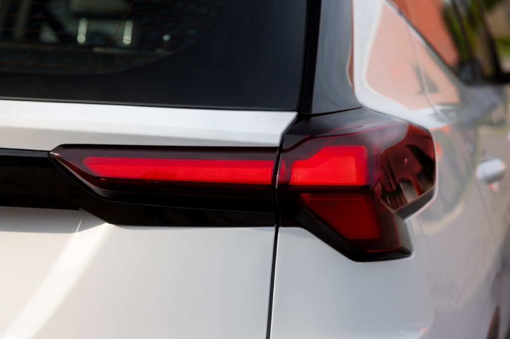 Red LED taillight with modern geometric design on white electric vehicle