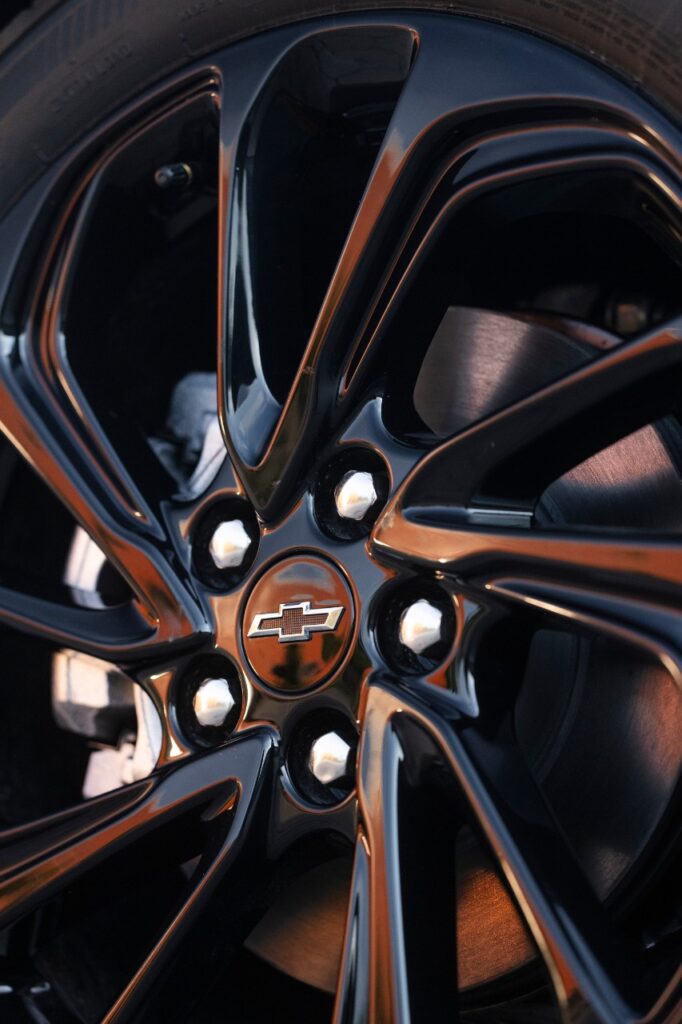 Black Chevrolet wheel with chrome bowtie logo center cap and modern spoke design