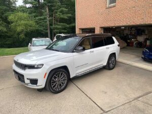 2023 Jeep Grand Cherokee L Summit Reserve in white parked in a driveway
