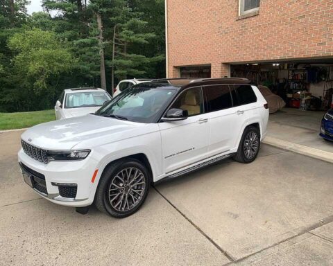 2023 Jeep Grand Cherokee L Summit Reserve in white parked in a driveway