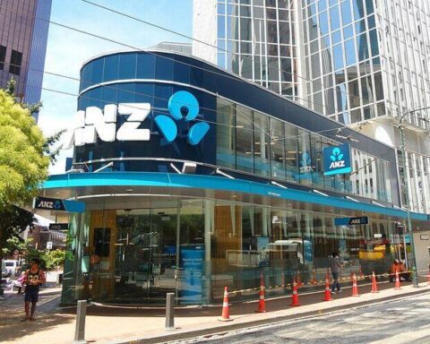 Street-level view of the ANZ Bank Tower on Lambton Quay in Wellington, New Zealand, showing a glass-fronted corner branch with the ANZ logo and pedestrians nearby.