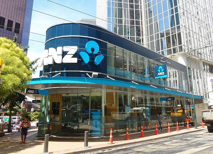 Street-level view of the ANZ Bank Tower on Lambton Quay in Wellington, New Zealand, showing a glass-fronted corner branch with the ANZ logo and pedestrians nearby.
