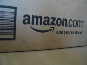 Close-up of an Amazon.com shipping box showing the company’s logo and slogan.
